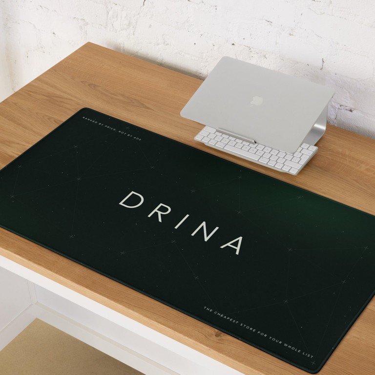 A long dark-green Drina desk mat under a keyboard and laptop